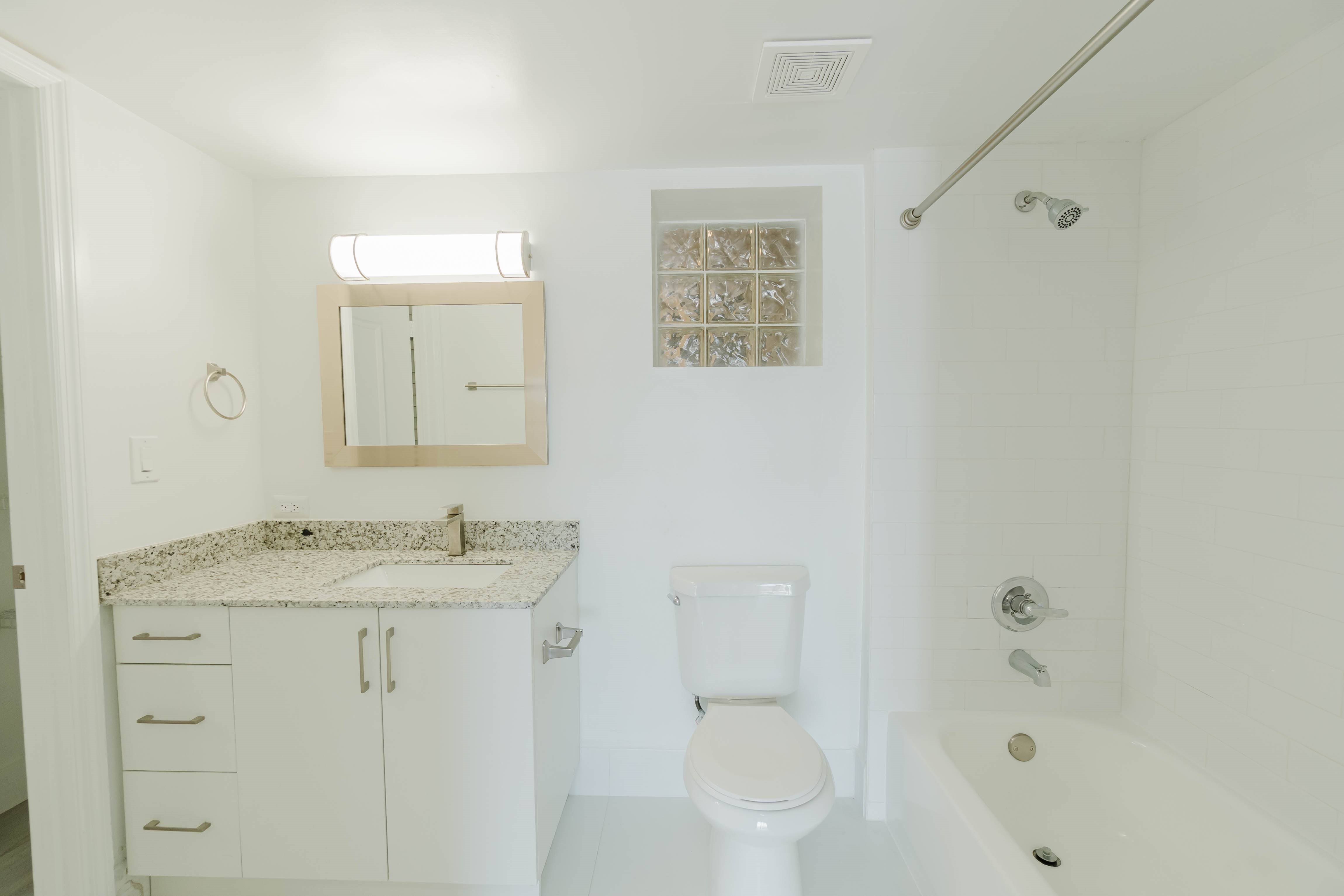 A white bathroom with a toilet, sink, and bathtub.